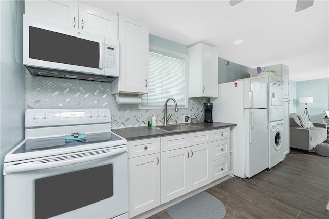 859 E 2nd St, Englewood, FL 34223 - kitchen with white appliances, a sink, dark countertops, white cabinets, and decorative backsplash