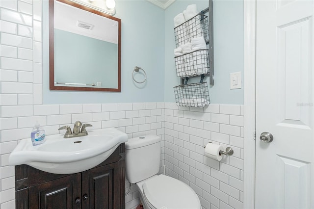 859 E 2nd St, Englewood, FL 34223 - half bath with tile walls, vanity, toilet, ornamental molding, and wainscoting