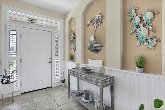 8127 Consul St, Port Charlotte, FL 33981 - foyer entrance with wainscoting, tile patterned floors, and arched walkways