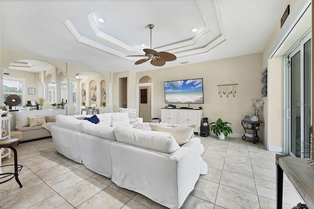 8127 Consul St, Port Charlotte, FL 33981 - living area with ornate columns, arched walkways, ceiling fan, and a tray ceiling