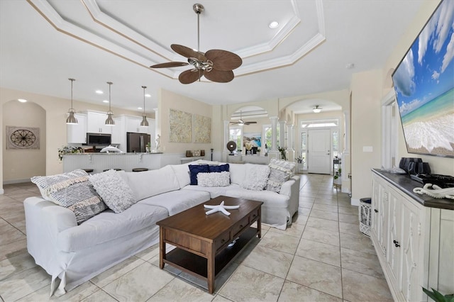 8127 Consul St, Port Charlotte, FL 33981 - living room with arched walkways, a tray ceiling, ceiling fan, ornate columns, and recessed lighting