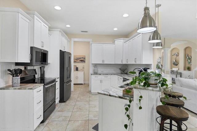 8127 Consul St, Port Charlotte, FL 33981 - kitchen featuring stainless steel appliances, white cabinetry, light stone counters, a kitchen bar, and decorative light fixtures