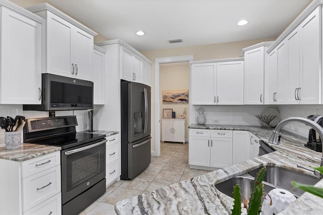 8127 Consul St, Port Charlotte, FL 33981 - kitchen with electric range, stainless steel fridge with ice dispenser, white cabinets, light stone countertops, and recessed lighting