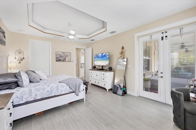 8127 Consul St, Port Charlotte, FL 33981 - bedroom featuring a tray ceiling, access to exterior, light wood-style floors, and ceiling fan