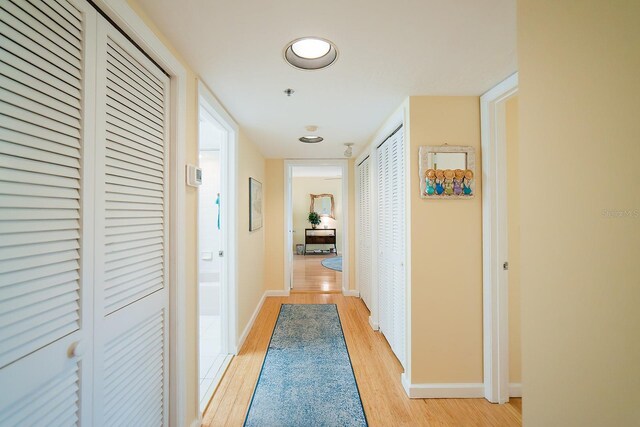 7303 Jessie Harbor Dr Unit 7303, Osprey, FL 34229 - hallway featuring light wood-type flooring and baseboards