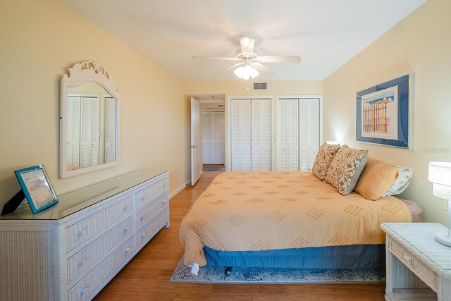7303 Jessie Harbor Dr Unit 7303, Osprey, FL 34229 - bedroom featuring two closets, light wood-type flooring, and a ceiling fan