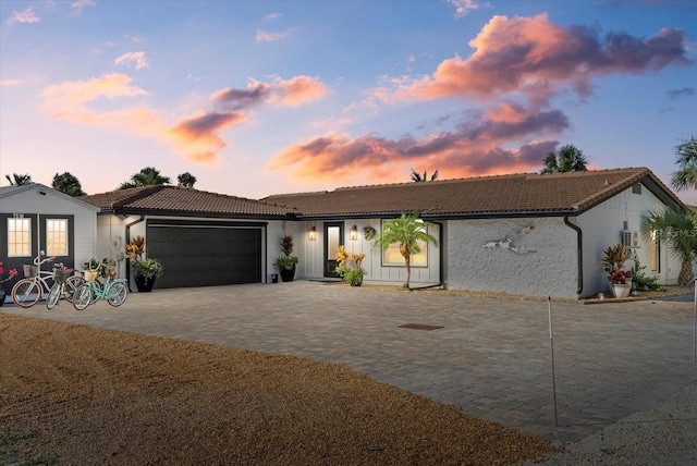 7530 Whitcomb St, Englewood, FL 34223 - single story home with a tile roof, an attached garage, decorative driveway, and stucco siding