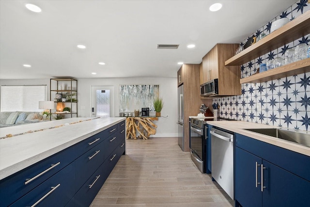 7530 Whitcomb St, Englewood, FL 34223 - kitchen featuring stainless steel appliances, open shelves, blue cabinets, light countertops, and recessed lighting