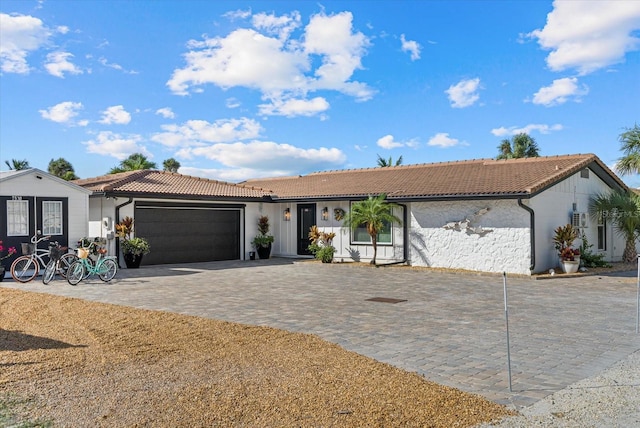 7530 Whitcomb St, Englewood, FL 34223 - ranch-style house featuring a tiled roof, an attached garage, decorative driveway, and stucco siding