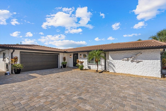 7530 Whitcomb St, Englewood, FL 34223 - view of front of home featuring a tile roof, decorative driveway, stucco siding, and a garage