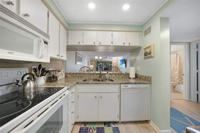 1501 Beach Rd Unit 310, Englewood, FL 34223 - kitchen featuring white appliances, a sink, light wood finished floors, white cabinets, and tasteful backsplash
