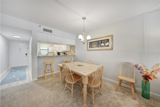 1501 Beach Rd Unit 310, Englewood, FL 34223 - dining room featuring a chandelier, light colored carpet, baseboards, and a textured ceiling