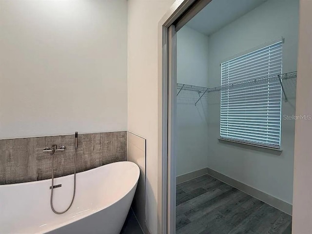311 Yule St, Port Charlotte, FL 33953 - bathroom with a freestanding bath, wood finished floors, and a walk in closet