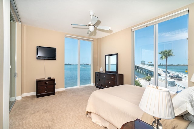 1375 Beach Rd Unit 201, Englewood, FL 34223 - bedroom featuring a water view, access to exterior, carpet, baseboards, and a ceiling fan