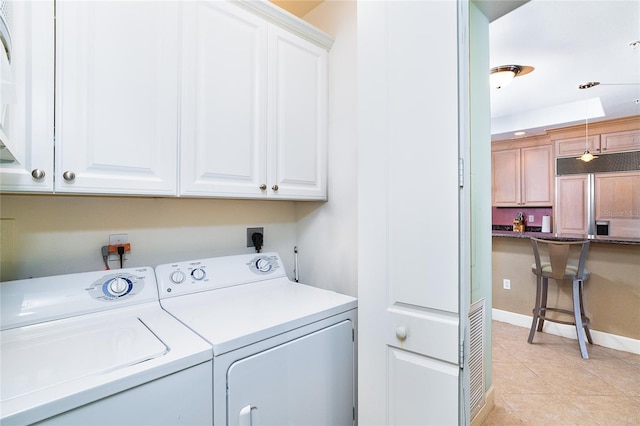 1375 Beach Rd Unit 201, Englewood, FL 34223 - laundry room with cabinet space, independent washer and dryer, light tile patterned floors, and baseboards