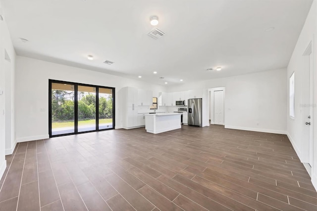 10242 Hallendale Dr, Port Charlotte, FL 33981 - unfurnished living room featuring baseboards, dark wood-style flooring, and recessed lighting
