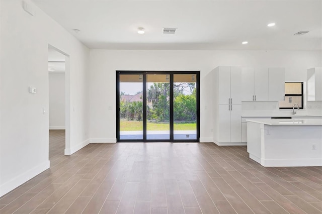 10242 Hallendale Dr, Port Charlotte, FL 33981 - unfurnished living room with baseboards, wood finished floors, recessed lighting, and a sink