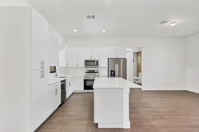 10242 Hallendale Dr, Port Charlotte, FL 33981 - kitchen with stainless steel appliances, dark wood-type flooring, a center island, a sink, and light countertops
