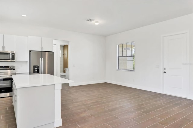 10242 Hallendale Dr, Port Charlotte, FL 33981 - kitchen with appliances with stainless steel finishes, light countertops, baseboards, wood finished floors, and a kitchen island