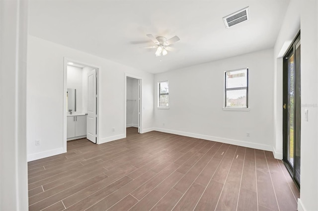 10242 Hallendale Dr, Port Charlotte, FL 33981 - unfurnished bedroom featuring baseboards, wood finished floors, ceiling fan, and ensuite bath