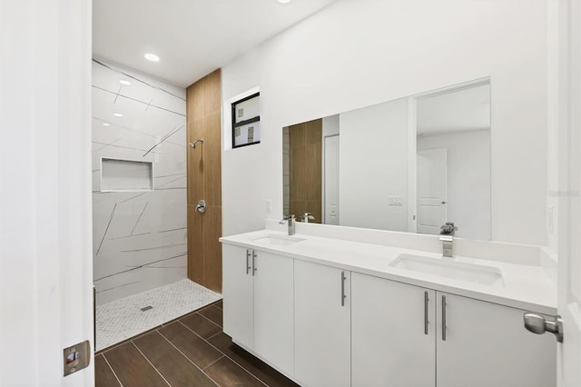 10242 Hallendale Dr, Port Charlotte, FL 33981 - bathroom featuring double vanity, tiled shower, wood finished floors, and recessed lighting
