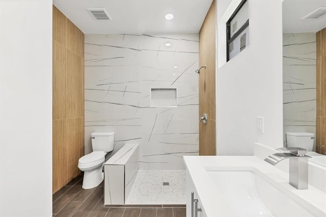 10242 Hallendale Dr, Port Charlotte, FL 33981 - bathroom featuring toilet, vanity, a stall shower, tile walls, and wood finish floors