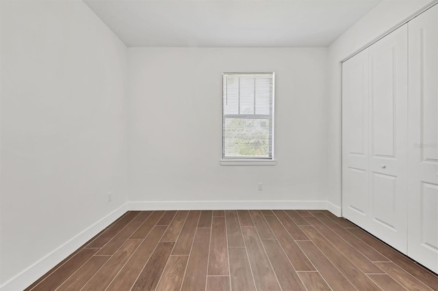 10242 Hallendale Dr, Port Charlotte, FL 33981 - unfurnished bedroom featuring dark wood finished floors, a closet, and baseboards