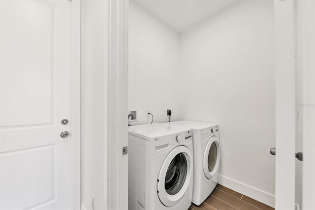 10242 Hallendale Dr, Port Charlotte, FL 33981 - laundry room with washing machine and clothes dryer, wood tiled floors, and baseboards