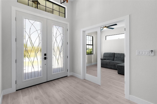 10454 Atenia St, Port Charlotte, FL 33981 - foyer entrance with french doors, baseboards, wood finished floors, ceiling fan, and a high ceiling