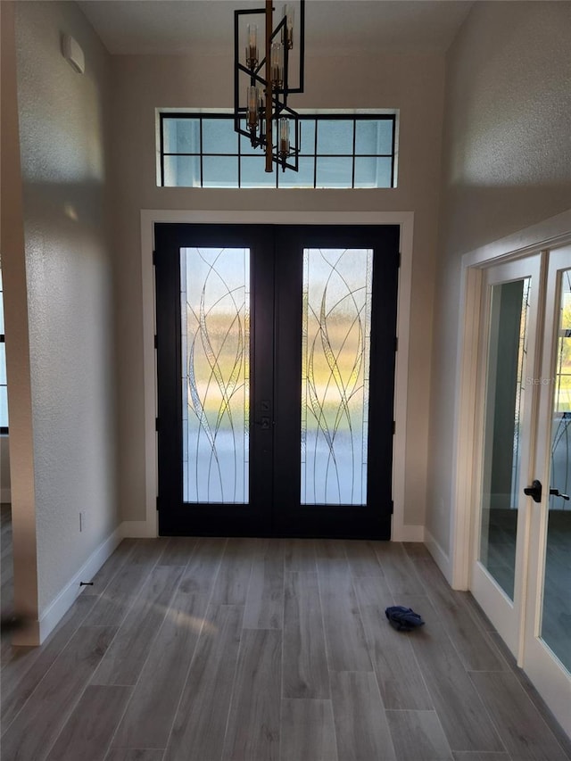10454 Atenia St, Port Charlotte, FL 33981 - entryway featuring french doors, a chandelier, wood finished floors, baseboards, and a high ceiling