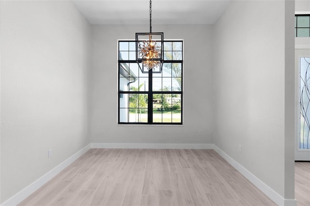 10454 Atenia St, Port Charlotte, FL 33981 - unfurnished dining area featuring light wood finished floors, a chandelier, healthy amount of natural light, and baseboards