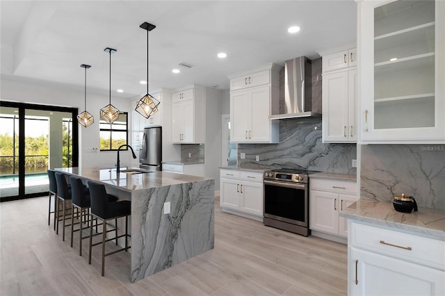 10454 Atenia St, Port Charlotte, FL 33981 - kitchen with wall chimney range hood, stainless steel appliances, a sink, decorative backsplash, and an island with sink