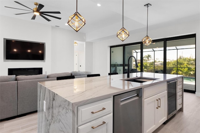 10454 Atenia St, Port Charlotte, FL 33981 - kitchen featuring beverage cooler, a sink, open floor plan, light stone countertops, and a kitchen island with sink