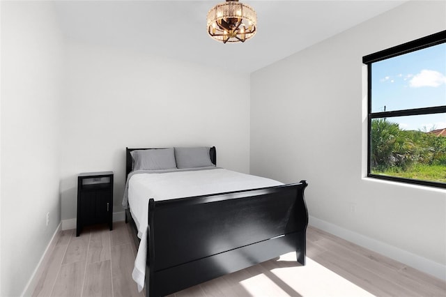 10454 Atenia St, Port Charlotte, FL 33981 - bedroom with a chandelier, light wood-style flooring, and baseboards