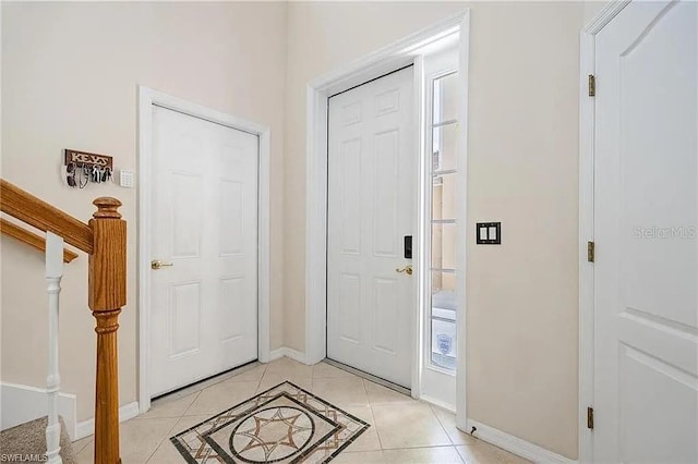 13091 Sandy Key Bnd Unit 104, North Fort Myers, FL 33903 - foyer with baseboards, stairway, and light tile patterned flooring