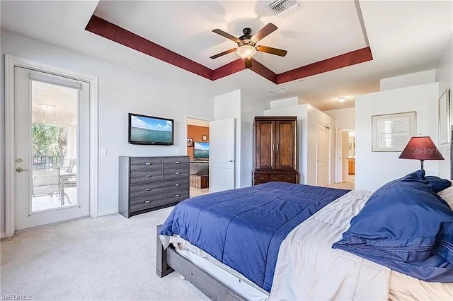 13091 Sandy Key Bnd Unit 104, North Fort Myers, FL 33903 - bedroom featuring a tray ceiling, access to outside, light colored carpet, connected bathroom, and baseboards
