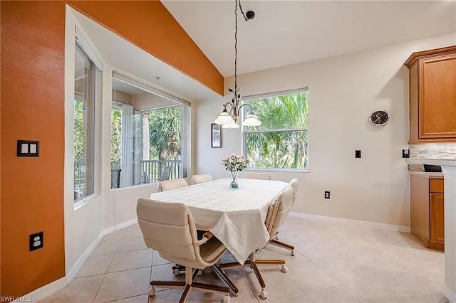 13091 Sandy Key Bnd Unit 104, North Fort Myers, FL 33903 - dining space with a chandelier, light tile patterned floors, baseboards, and vaulted ceiling