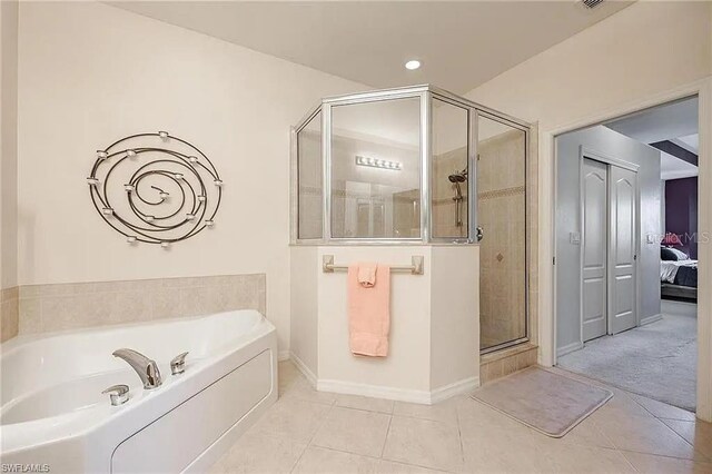 13091 Sandy Key Bnd Unit 104, North Fort Myers, FL 33903 - full bath featuring a shower stall, a bath, tile patterned floors, baseboards, and ensuite bathroom