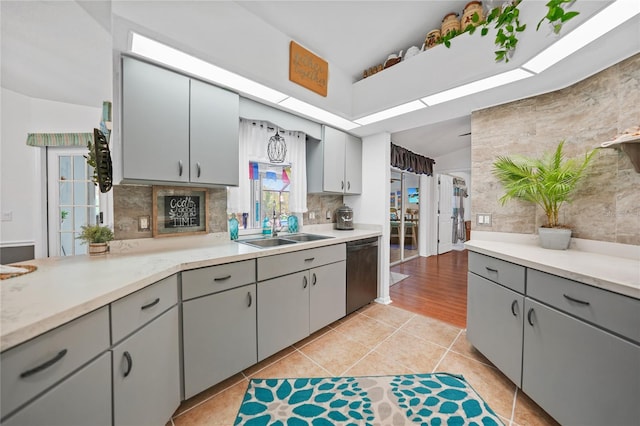13703 Drysdale Ave, Port Charlotte, FL 33981 - kitchen with stainless steel dishwasher, a sink, gray cabinets, light countertops, and lofted ceiling