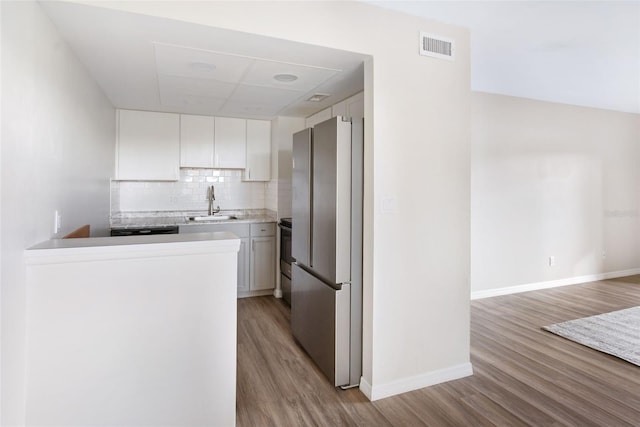 96 Boundary Blvd Unit 112, Rotonda West, FL 33947 - kitchen featuring freestanding refrigerator, light wood-style flooring, a sink, baseboards, and white cabinets
