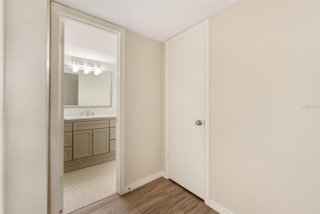96 Boundary Blvd Unit 112, Rotonda West, FL 33947 - unfurnished bedroom with wood finished floors, baseboards, a sink, and ensuite bathroom