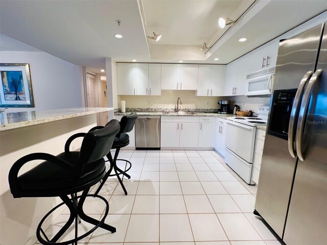 2380 N Beach Rd Unit 210, Englewood, FL 34223 - kitchen featuring appliances with stainless steel finishes, light tile patterned floors, a sink, white cabinets, and recessed lighting