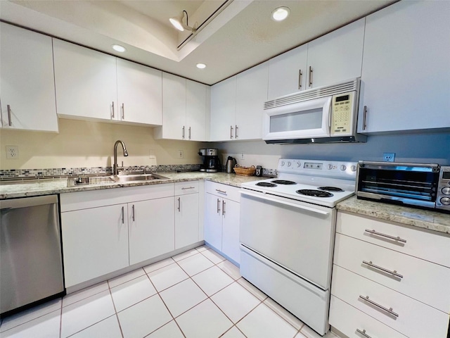 2380 N Beach Rd Unit 210, Englewood, FL 34223 - kitchen with white appliances, a sink, white cabinetry, recessed lighting, and light tile patterned floors