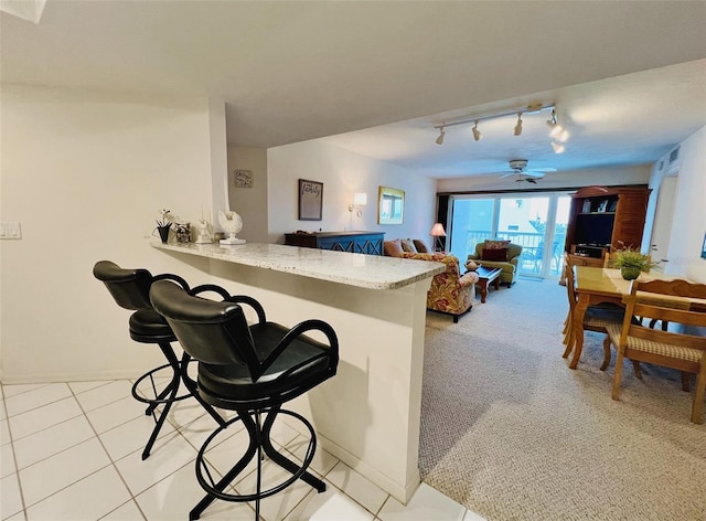 2380 N Beach Rd Unit 210, Englewood, FL 34223 - kitchen with ceiling fan, a breakfast bar area, rail lighting, a peninsula, and baseboards
