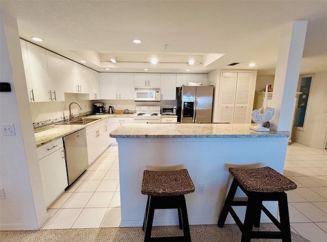 2380 N Beach Rd Unit 210, Englewood, FL 34223 - kitchen with stainless steel appliances, a raised ceiling, a sink, a kitchen breakfast bar, and recessed lighting