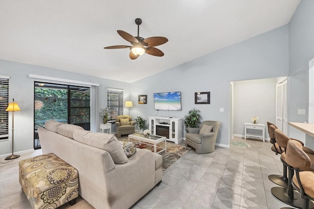 534 Wekiva River Ct Unit 103, Englewood, FL 34223 - living area with ceiling fan, a fireplace, high vaulted ceiling, baseboards, and light tile patterned flooring