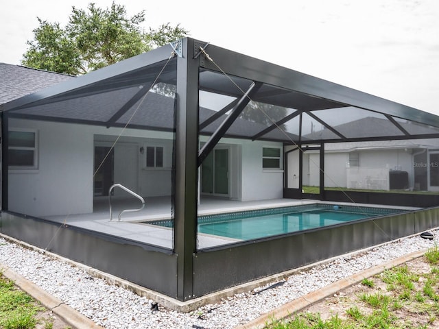 21 Sportsman Way, Rotonda West, FL 33947 - rear view of house with glass enclosure, an outdoor pool, a patio, and roof with shingles