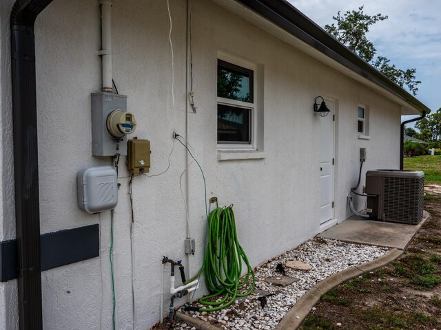 21 Sportsman Way, Rotonda West, FL 33947 - view of side of home with stucco siding and central air condition unit