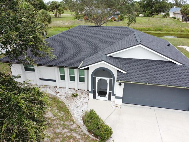 21 Sportsman Way, Rotonda West, FL 33947 - ranch-style home featuring roof with shingles, an attached garage, stucco siding, and driveway