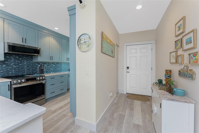 8405 Placida Rd Unit 406, Placida, FL 33946 - kitchen with appliances with stainless steel finishes, light wood finished floors, decorative backsplash, light stone countertops, and recessed lighting
